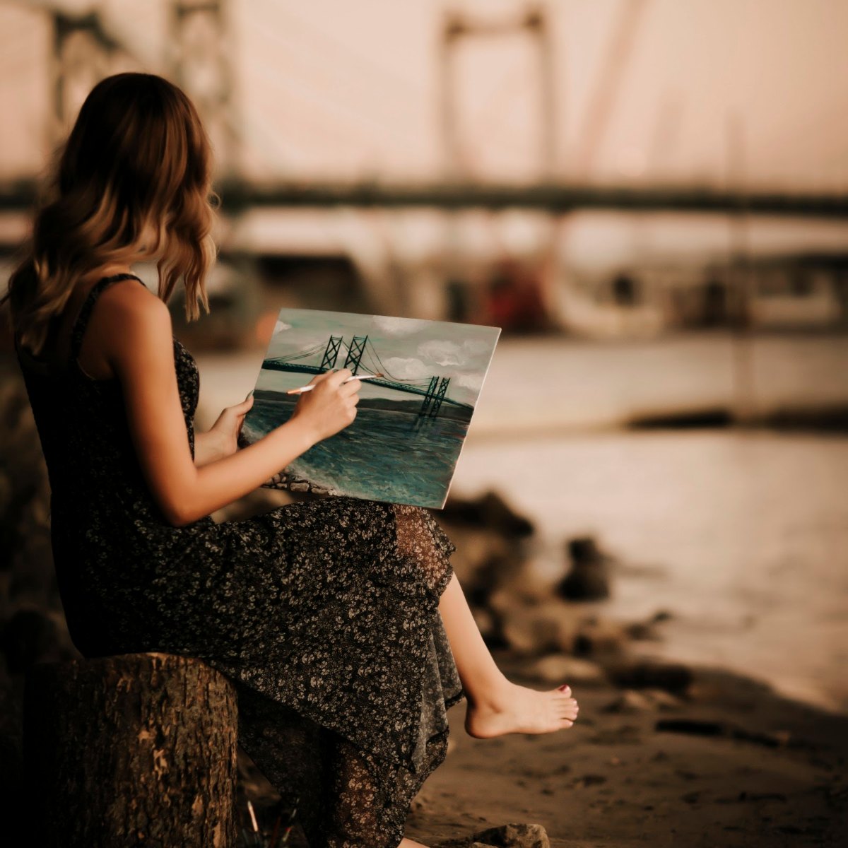 Paige painting a river bridge outdoors
